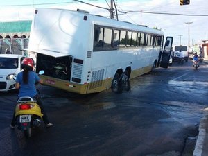 Ônibus atola em rua asfaltada após erosão provocada por vazamento