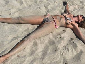 Luciana Gimenez se joga na areia e lamenta fim das férias em Ibiza
