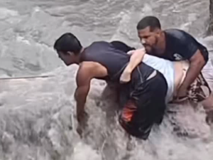 Homem usa corda para resgatar idosa durante enxurrada na periferia de Maceió