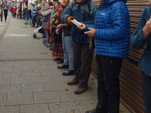 Voluntários fazem corrente humana para transportar livros em mudança de livraria