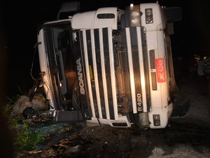 Carreta lotada de aguardente tomba e deixa motorista ferido na BR-101