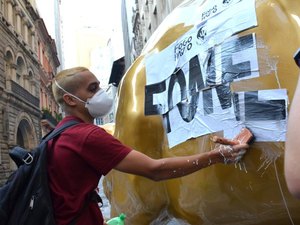 Escultura do “touro de ouro” amanhece pichada e com cartaz contra a fome