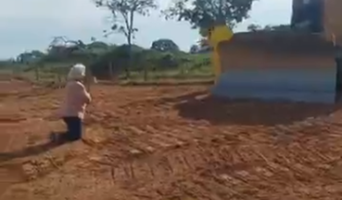 Idosa se ajoelha para tentar impedir máquina de entrar em fazenda para obra de duplicação da GO-330