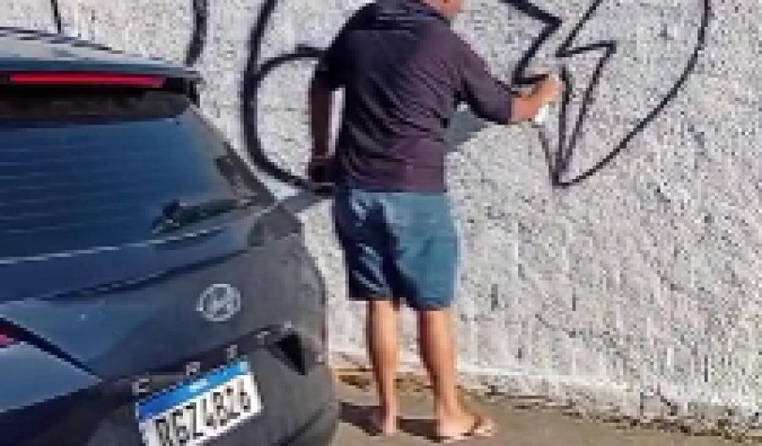 Homem é flagrado pichando muro recém-pintado de cemitério em Maceió