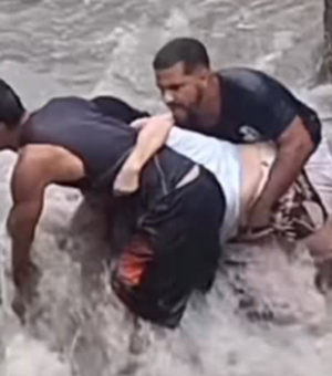 Homem usa corda para resgatar idosa durante enxurrada na periferia de Maceió