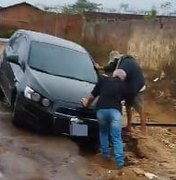 Carro atola em cratera aberta pelas fortes chuvas no bairro Arnon de Mello, em Arapiraca