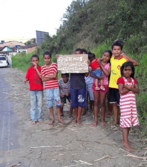 Crianças carentes erguem placa às margens de rodovia para pedir presentes