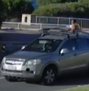 Criança de 4 anos é vista sobre teto de carro, enquanto mãe dirige