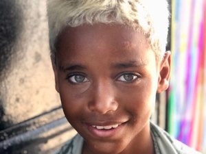 Menino da Cidade de Deus viraliza após foto em portão de ONG e entra para agência de modelos