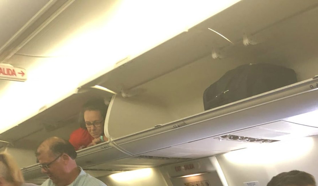 Comissária de bordo se coloca em bagageiro durante embarque de passageiros nos EUA