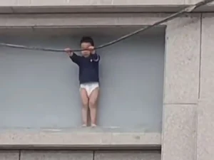 Menino de 3 anos fica preso do lado de fora de prédio a 10 metros de altura na China