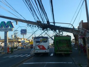 Dois postes de energia caem, atingem veículos e deixam duas pessoas feridas