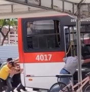 População é vista empurrando ônibus no terminal do Conjunto Graciliano Ramos, em Maceió