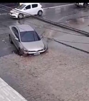Após chuvas, buraco na pista  ‘engole’ carro no bairro Clima Bom