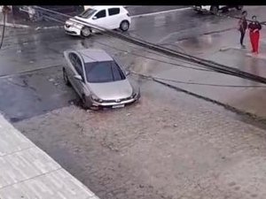 Após chuvas, buraco na pista  ‘engole’ carro no bairro Clima Bom