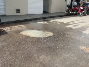 Cano estourado faz buracos na rua em frente a colégio do Jacintinho