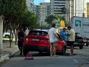 Carro cai em cratera aberta após chuvas no bairro da Ponta Verde, em Maceió