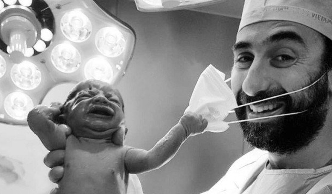 Foto de recém-nascido puxando máscara de médico viraliza na internet