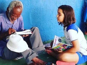 Criança ensina vendedor de picolé a ler e a escrever em chão de pátio da escola