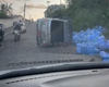 Caminhão carregado com água mineral capota no bairro do Jacintinho, em Maceió