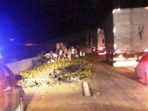 Caminhão carregado com laranjas tomba na BR-101 e carga é saqueada