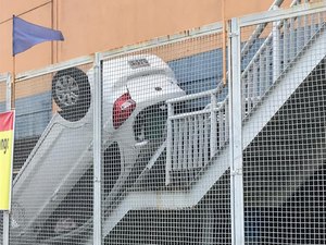 Carro vai parar em escada externa de supermercado após capotamento