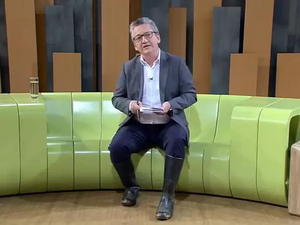 Com estúdio alagado, jornalista apresenta jornal usando galochas