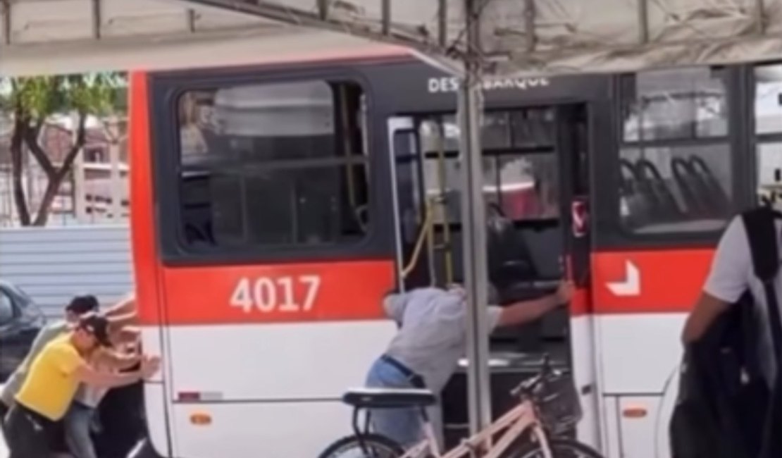 População é vista empurrando ônibus no terminal do Conjunto Graciliano Ramos, em Maceió